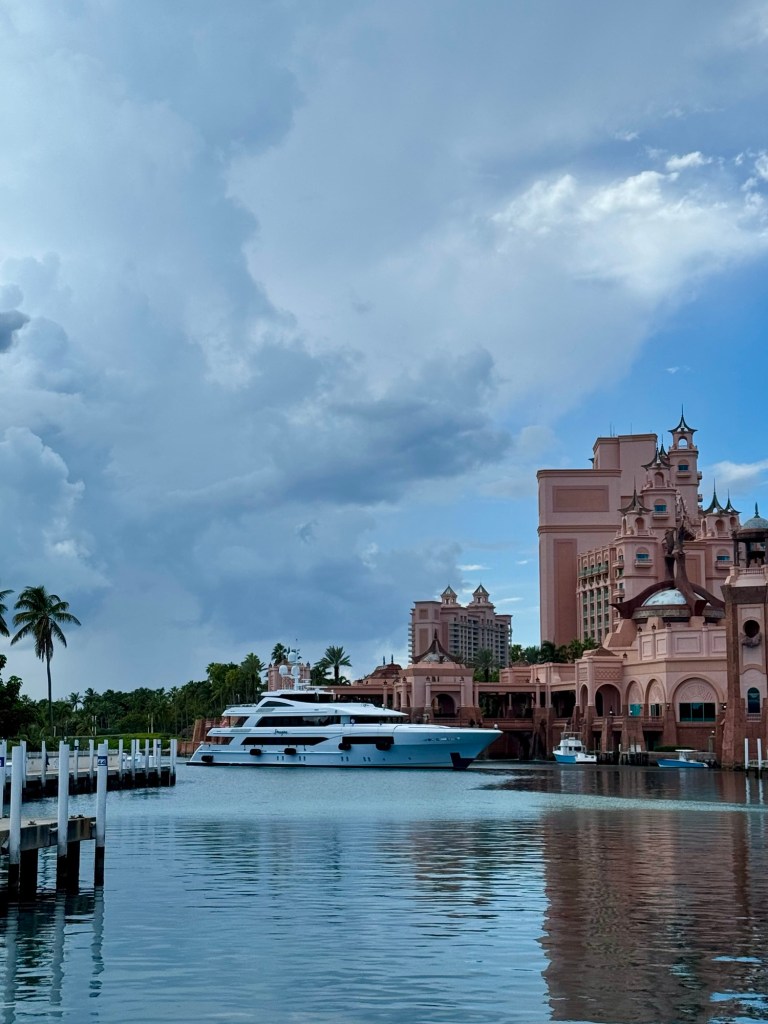 Yacht entering a marina with Atlantis resort in the background