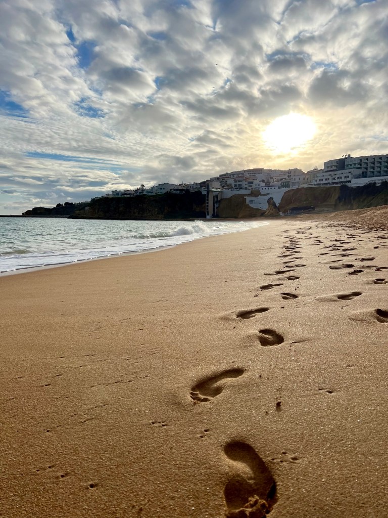 Footsteps along a beach in Albufeira, Portugal at sunset
