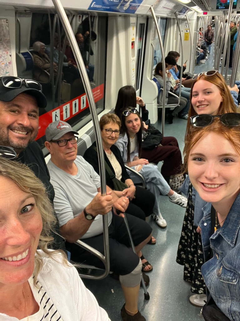 Family aboard a subway train, some sitting, some standing