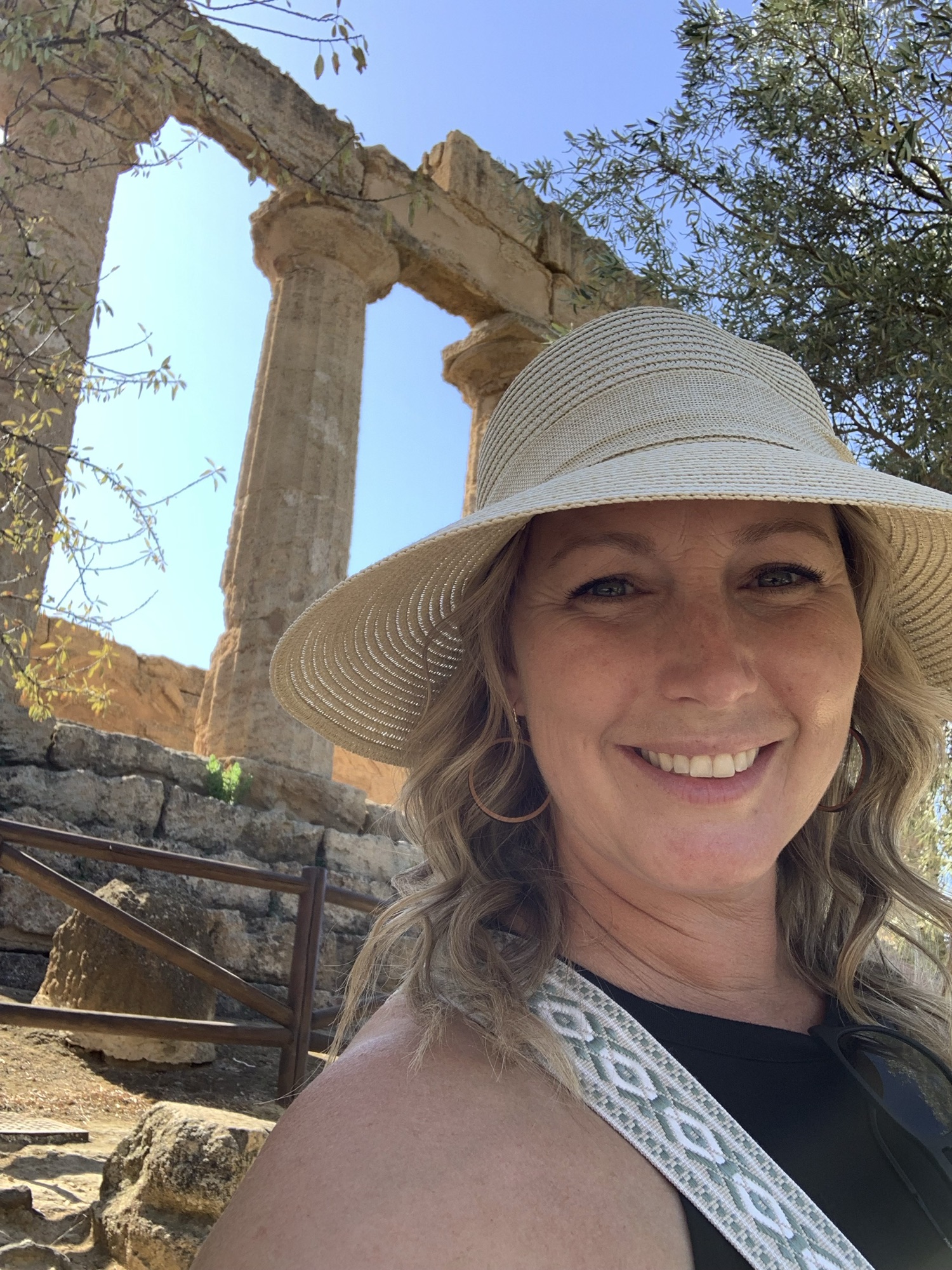 Image of woman in hat in front of archeological ruins