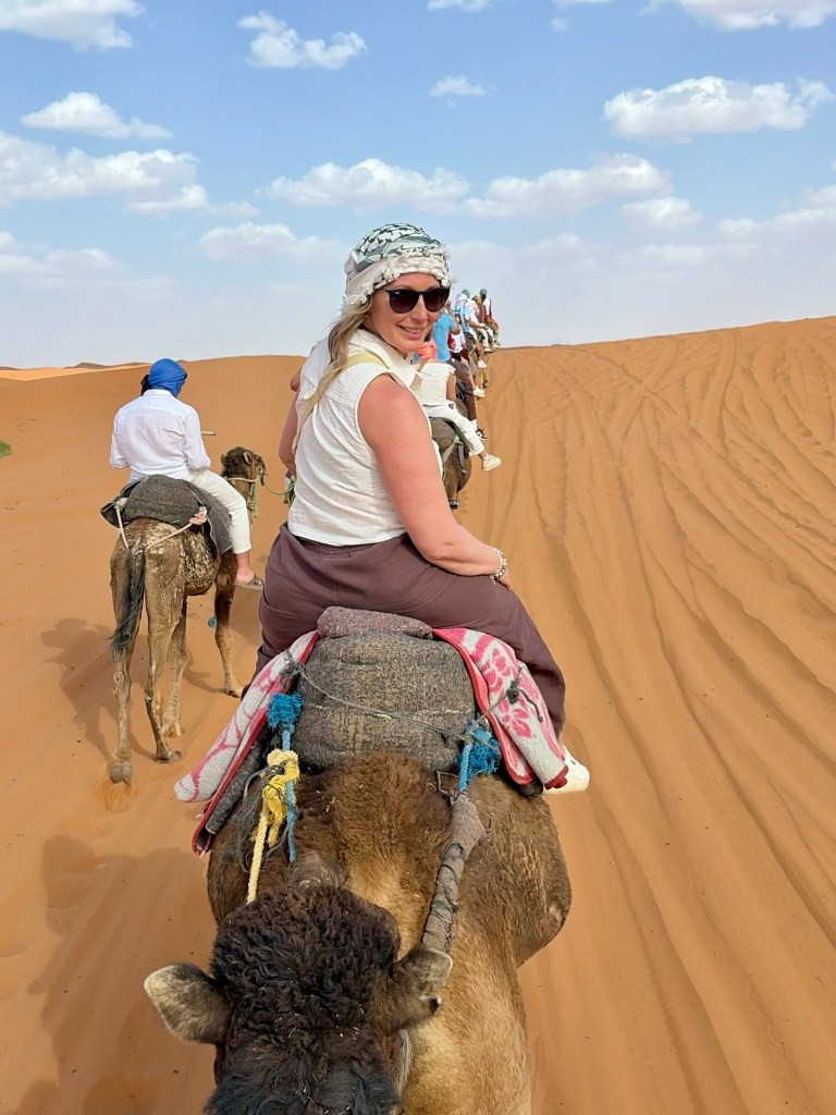 Woman riding a camel looking back towards the camera