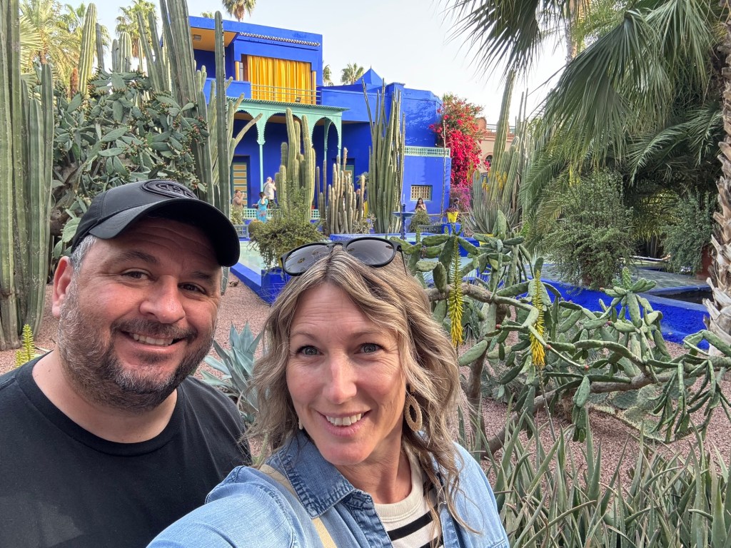 Couple in front of a bright blue building in a garden setting