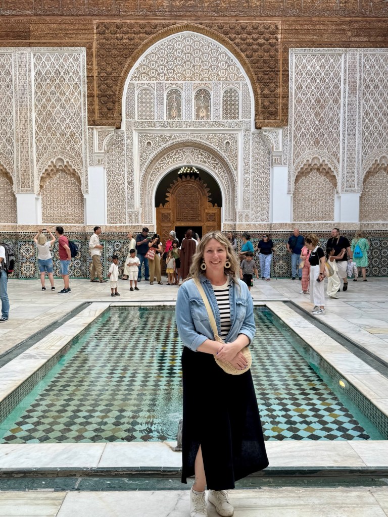 Woman standing in front of a pool in a courtyard