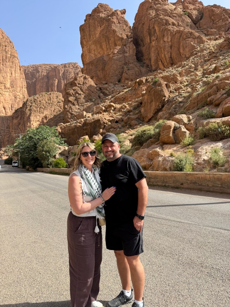 Couple standing on a road with a rock canyon in the background