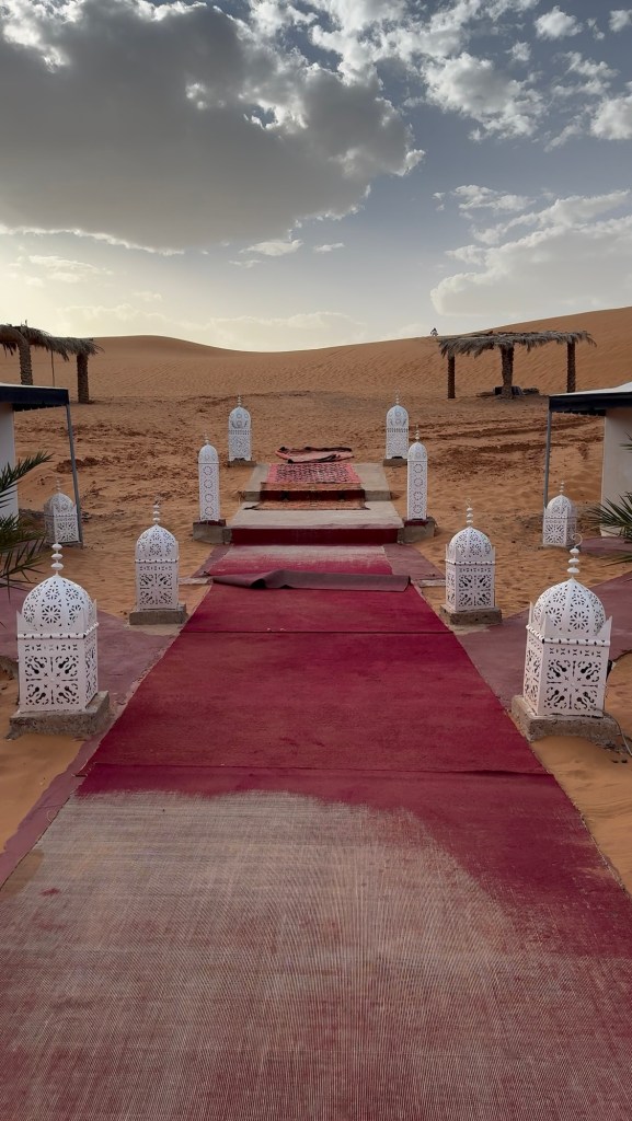 Carpet runner flanked by moroccan lamps in the desert