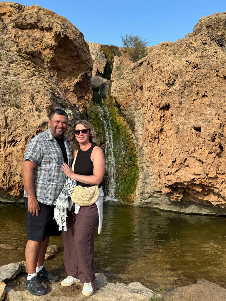 Man and woman standing in front of a small waterfall