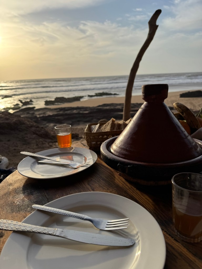 Tagine and plates on table overlooking the ocean